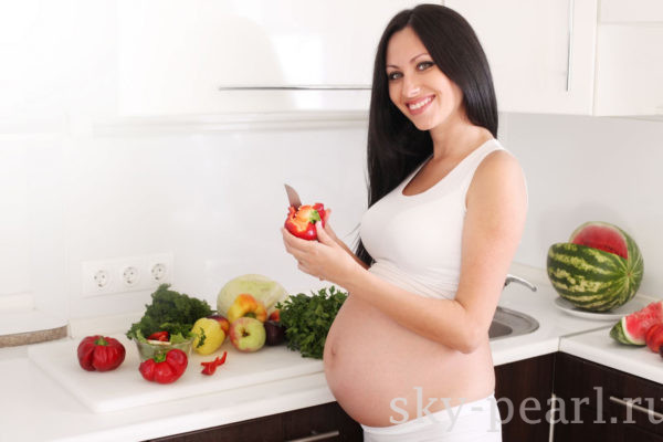 беременная девушка готовит
